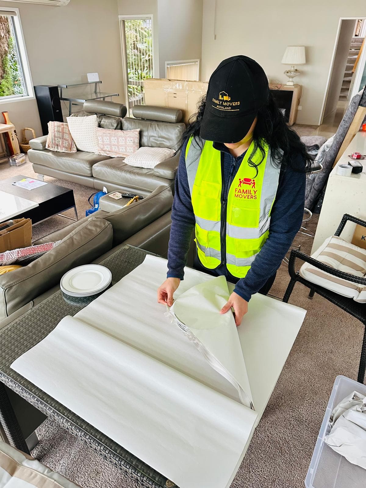 Family Movers team member packing moving boxes carefully